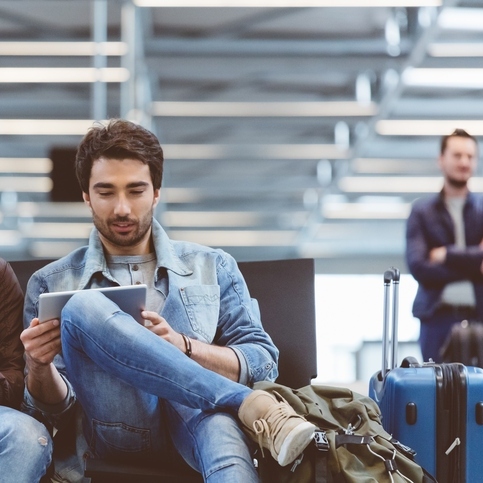 Handsome men waiting for flight in airport terminal
