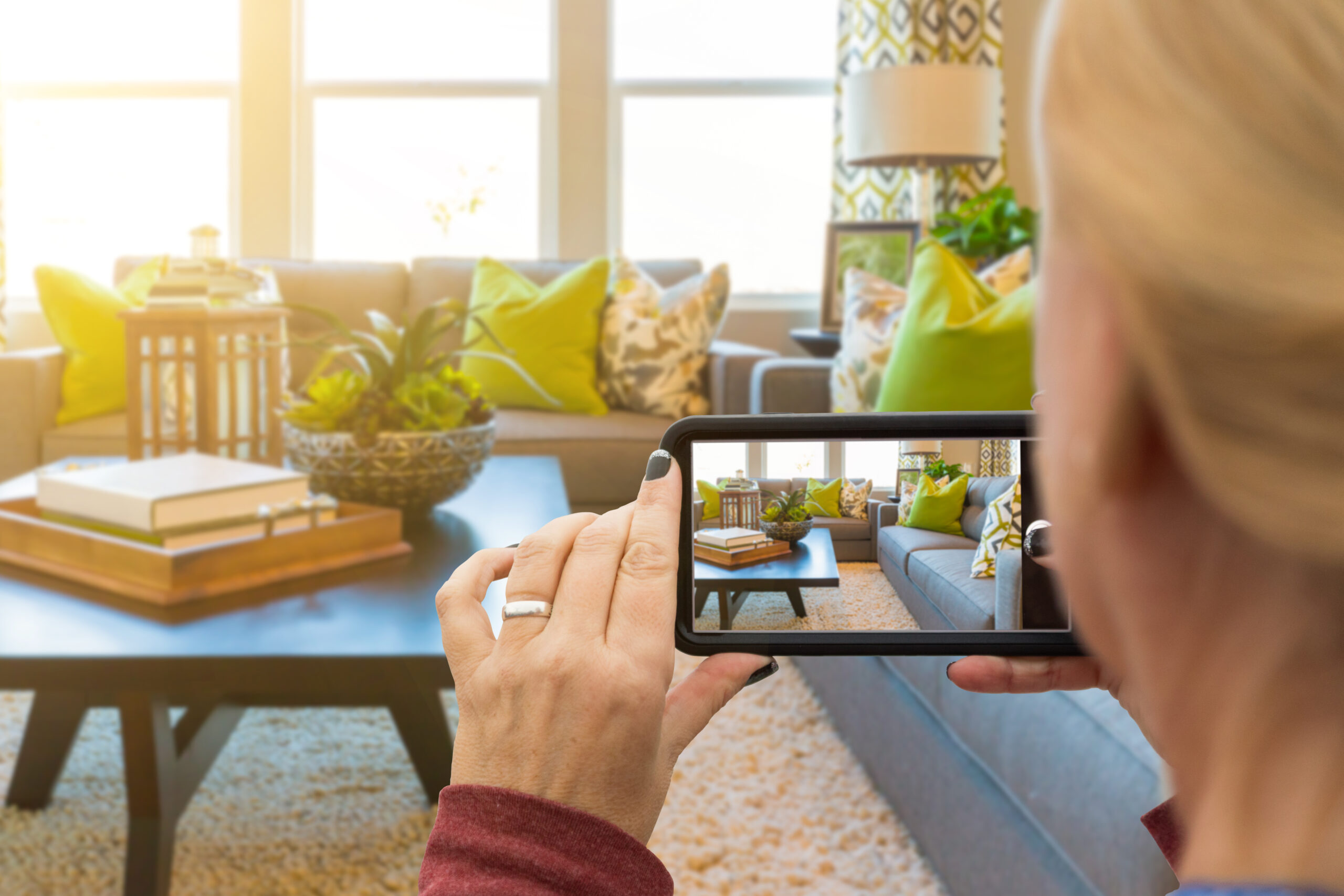 Woman Taking Pictures of A Living Room in Model Home with Her Smart Phone